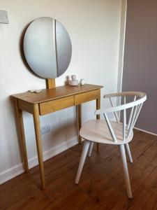 une table en bois avec un miroir et une chaise dans l'établissement Teach Róise, à Dunfanaghy