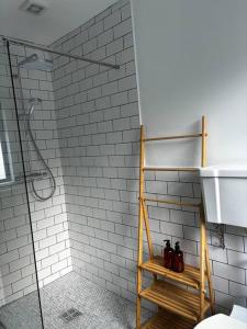 La salle de bains est pourvue d'une douche et d'une étagère en bois. dans l'établissement Teach Róise, à Dunfanaghy