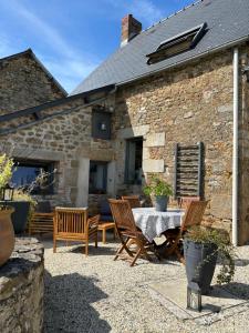 eine Terrasse mit Stühlen und einem Tisch vor einem Gebäude in der Unterkunft Gite le Patis in Pré-en-Pail