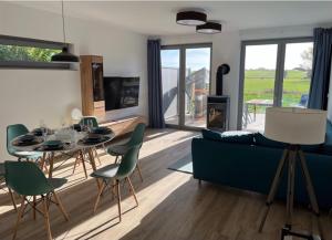 a living room with a blue couch and a table and chairs at The Fehmarn Lodges - EMOTION - in Fehmarn