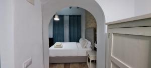 1 dormitorio con cama blanca y espejo en Casa Vladimir en Arcos de la Frontera