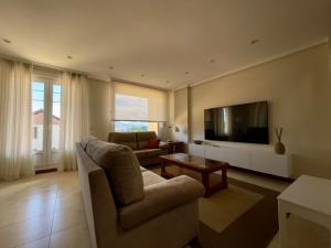 - un salon avec un canapé et une télévision dans l'établissement Villa Los Olivos, à Bárcena de Cicero