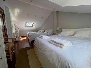 - une chambre blanche avec 2 lits et un canapé dans l'établissement Villa Los Olivos, à Bárcena de Cicero