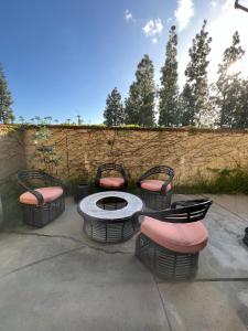 um pátio com 4 cadeiras e uma mesa com uma fogueira em 3 bedroom modern home with pool area at the Tustin Marketplace -15 minutes to Disneyland em Tustin
