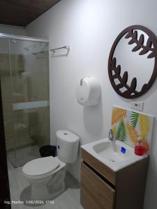 bagno con servizi igienici, lavandino e specchio di Casa Hotel El Cafetal a Cumaral