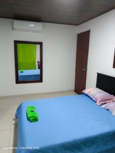 een slaapkamer met een bed met een groene tas erop bij Casa Hotel El Cafetal in Cumaral