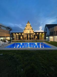 a house with a swimming pool at night at Qafqaz Mountside Chalet in Gabala