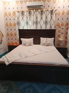 a large bed with white sheets and pillows at Al Madina Guest House in Hyderabad