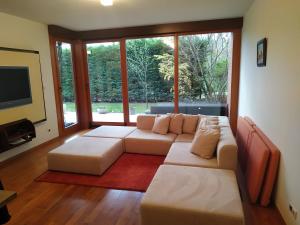 uma sala de estar com um sofá e uma grande janela em Aquincum Dunaparti Apartman em Budapeste