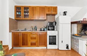 a kitchen with wooden cabinets and a white refrigerator at Apartment with Whirlpool and BBQ near Poreč in Baderna