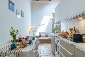 kuchnia i salon ze stołem w obiekcie Del Moro Home Pesaro Centro Mare by Yohome w mieście Pesaro