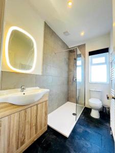 a bathroom with a sink and a shower and a toilet at The Springfield Hotel in Fairbourne