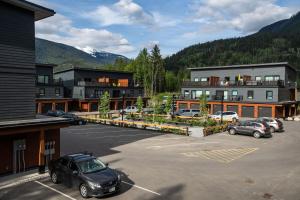 un aparcamiento con coches estacionados frente a los edificios en L'Austin Rêve by Revelstoke Vacations, en Revelstoke