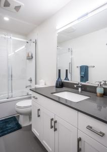 Baño blanco con lavabo y aseo en L'Austin Rêve by Revelstoke Vacations, en Revelstoke