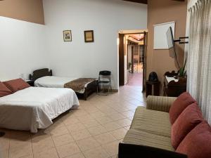 une chambre d'hôtel avec deux lits et un canapé dans l'établissement Apartamento con jardin, à Cochabamba