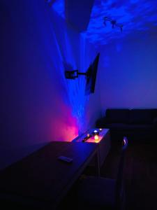 una camera con divano e tavolo con luce blu di Estudio ROOM Madrid Centro 1 DORMITORIO PARA DOS Y SOFA a Madrid