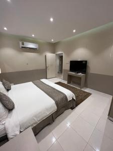 a bedroom with a bed and a flat screen tv at شاليه كادي cady resort in Al Khobar