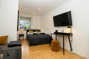 a bedroom with a bed and a flat screen tv at LIGHTPLACE • Große Unterkunft • 3 Schlafzimmer • Boxspring • Smart TV • Biergarten • Restaurant in Braunschweig