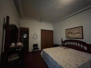 una camera da letto con un letto e una sedia di Misión Vizcaya Hospedaje a Durango