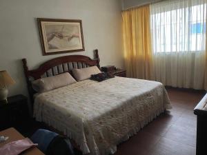 een slaapkamer met een bed en een raam bij Misión Vizcaya Hospedaje in Durango