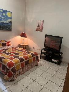 um quarto com uma cama e uma televisão de ecrã plano em Misión Vizcaya Hospedaje em Durango
