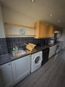 uma cozinha com um lavatório e uma máquina de lavar roupa em Chippenham Place, 3 Bedroom House, NG5 em Nottingham