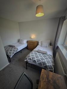um pequeno quarto com duas camas e uma mesa em Chippenham Place, 3 Bedroom House, NG5 em Nottingham