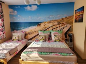 a bedroom with two beds and a mural of a beach at Willa Aldona in Jastrzębia Góra
