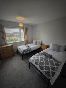 - une chambre avec 2 lits et une fenêtre dans l'établissement Chippenham Place, 3 Bedroom House, NG5, à Nottingham