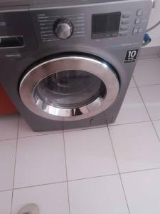 a washing machine in a room with a tile floor at Escape the noise in Dambani