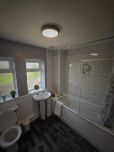 La salle de bains est pourvue de toilettes, d'un lavabo et d'une douche. dans l'établissement Chippenham Place, 3 Bedroom House, NG5, à Nottingham