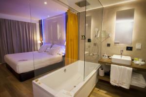 a bathroom with a bed and a tub and a sink at MB Boutique Hotel - Adults Recommended in Nerja