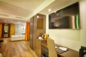 a room with a desk and a television on the wall at MB Boutique Hotel - Adults Recommended in Nerja