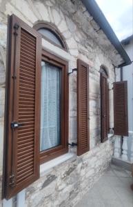 a window with wooden shutters on a stone building at ThassCities Casa Studios in Limenas