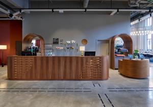 a restaurant with a wooden counter and a bar at Clarion Collection Hotel Tapetfabriken in Stockholm