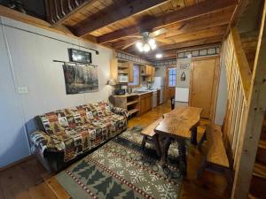 a living room with a couch and a table at Cute Cabin creek & Firepit #12 in Helen