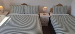 a bedroom with two beds and a night stand at Doolin Farm Apartment in Doolin