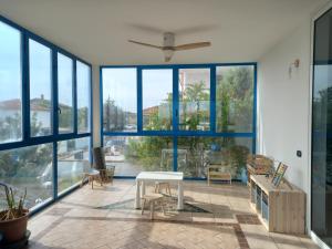 salon z dużymi oknami i białym stołem w obiekcie Villa Acquamarina w mieście Calasetta
