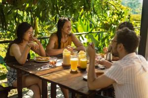 a group of people sitting around a wooden table at Casa Adobe Finca in La Peña