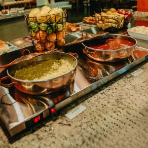 a buffet with three bowls of food on a counter at Paraty Hotel Fazenda & Spa in Ibiúna