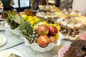 a table topped with bowls of fruit and other desserts at Hotel Golden Star in Curitiba