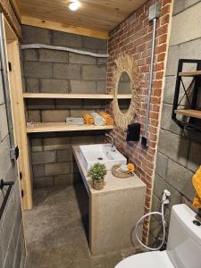 a bathroom with a sink and a brick wall at Lily's motel in El Alamein