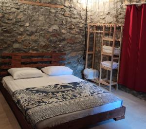 a bedroom with a bed and a brick wall at Togo iztuzu Stonehouse-4 in Boğazağzı