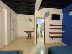 ein Schlafzimmer mit einer blauen Wand und einem Tisch sowie einem Zimmer in der Unterkunft Cruz Roja - Turismo Solimões in Leticia