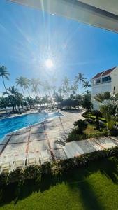 a view of a resort with a pool and palm trees at Promo Viviendas Sol y Mar in Juan Dolio