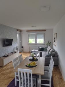 ein Wohnzimmer mit einem Sofa und einem Tisch in der Unterkunft GRAND BB Apartman in Bajina Bašta