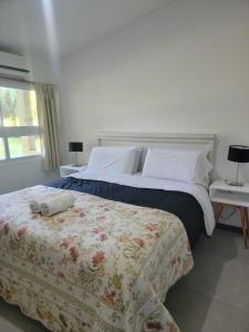 a bedroom with a large bed and two tables with lamps at VILLAGE PARK in Tandil