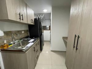 een kleine keuken met een wastafel en een koelkast bij Apartaloft en el centro 204 in Pereira