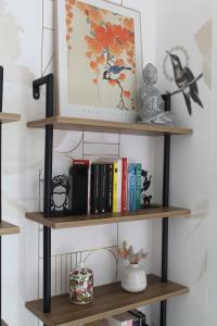 a shelf with books and other items on it at Le jardin de Clémentine in Wingersheim