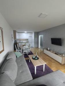 ein Wohnzimmer mit einem Sofa und einem Tisch in der Unterkunft GRAND BB Apartman in Bajina Bašta